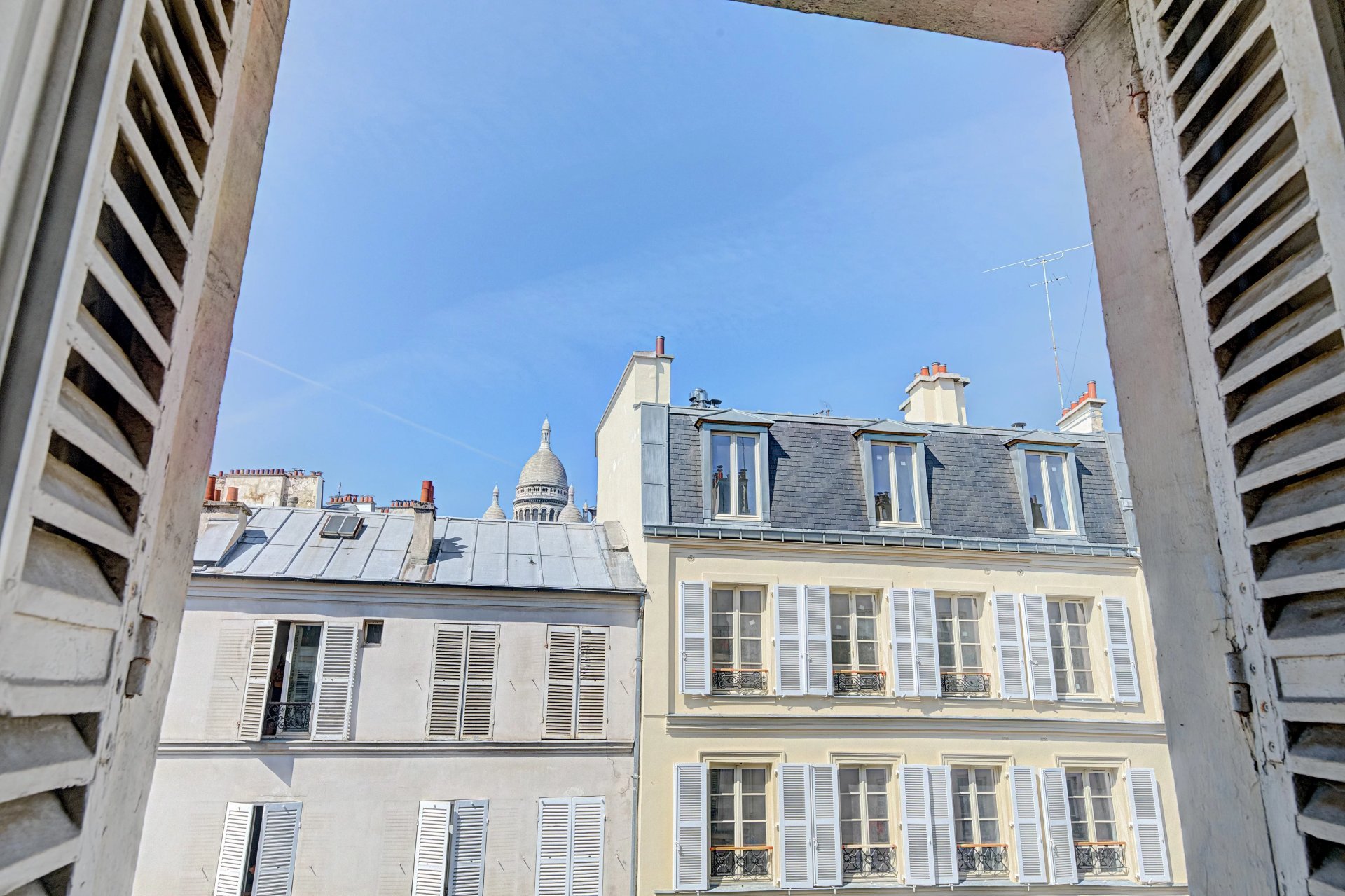 Vue sur les toits parisiens depuis la fenêtre